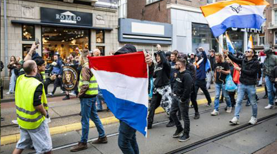 Demonstranten geflankeerd door politie gestart met mars Amsterdam