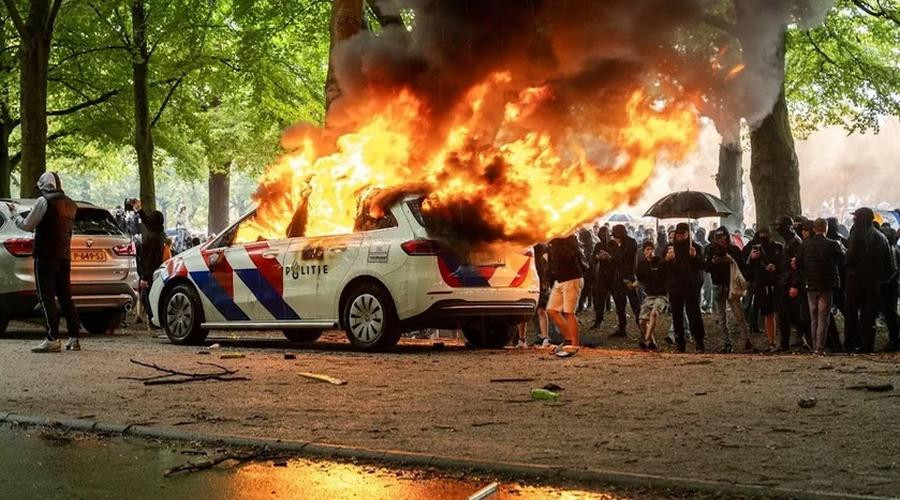 Betogers op Malieveld in Den Haag steken politieauto's in brand